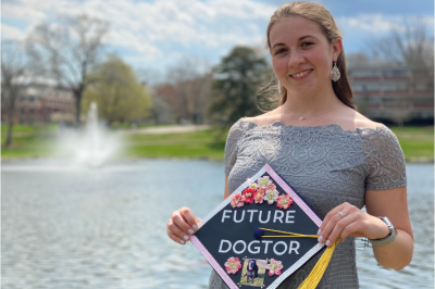 UConn Animal Science graduate posing with a decorated mortarboard