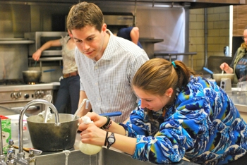 Dr. Dennis D'Amico oversees a student making mozzarella